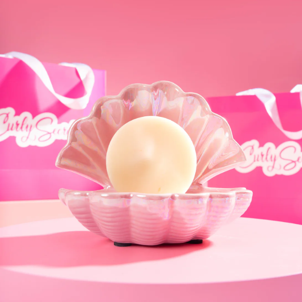 Drie verschillende shampoo- en conditioner bars op een roze schaaltje, met de witte conditioner bar op de voorgrond.