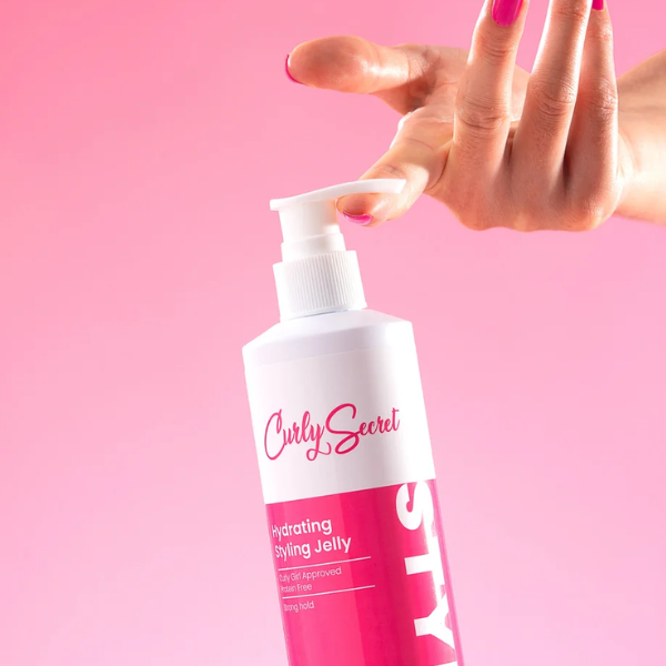 Curly Secret Hydrating Styling Jelly die vast wordt gehouden door iemand