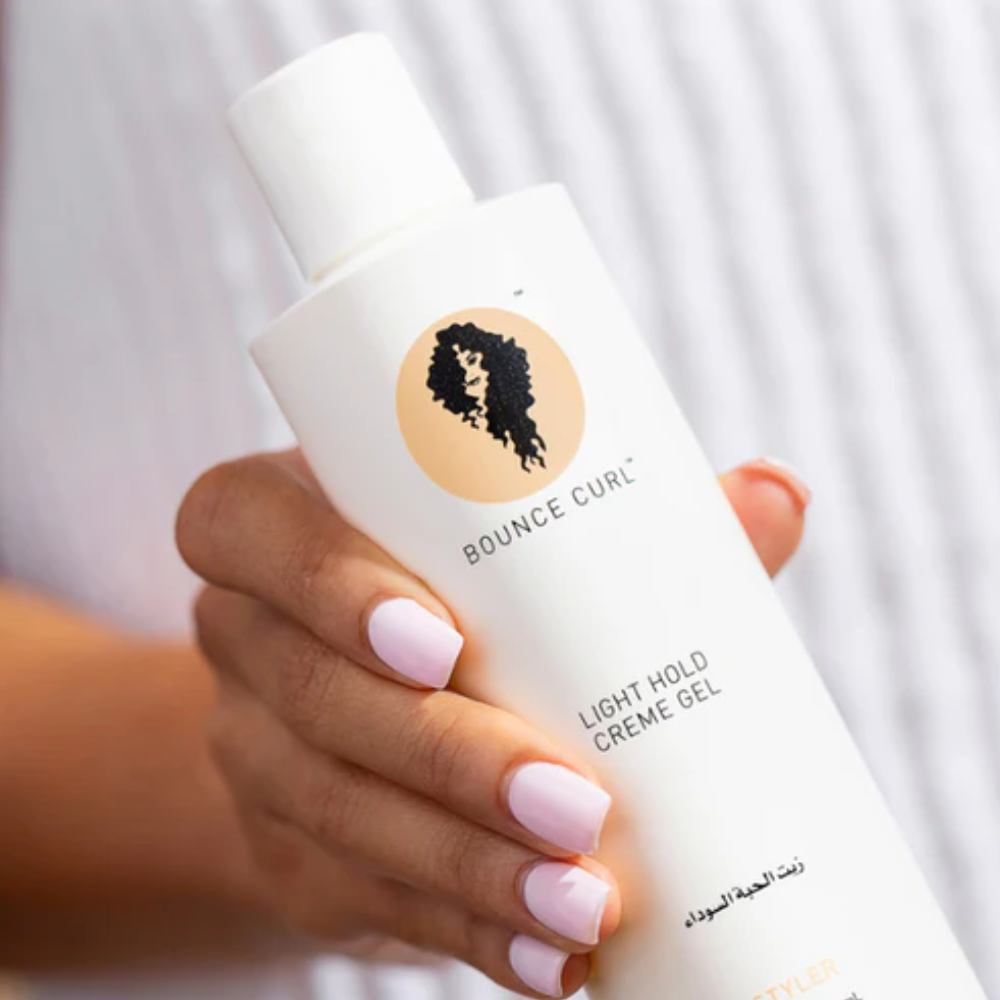 Iemand die de Bounce Curl Creme Light Hold Gel vast houdt