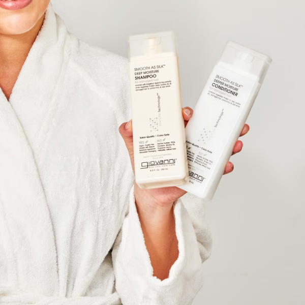 Iemand houdt Giovanni Cosmetics Smooth as Silk Shampoo en conditioner vast