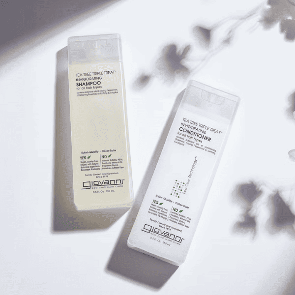 Giovanni Cosmetics Tea Tree Triple Treat Invigorating Shampoo en conditioner liggend met schaduw van planten