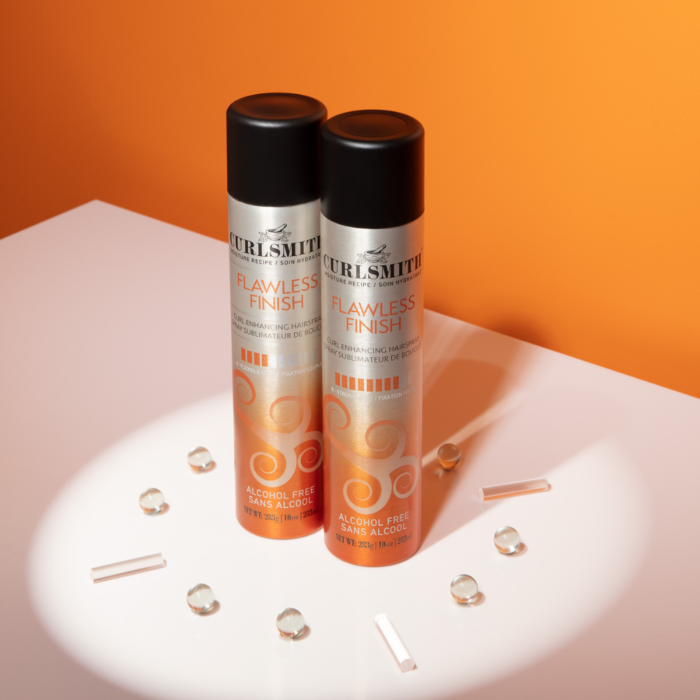 Curlmith Haarsprays in de studio met oranje achtergrond
